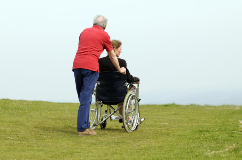 man pushing woman in wheelchair: Classic Vans Mobility & Wheelchair Vans article